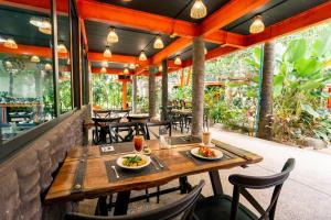 ein Restaurant mit einem Holztisch und Stühlen in der Unterkunft WOW PHUKET in Phuket