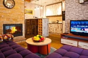 a living room with a couch and a table with a bowl of fruit at Wolf Apartments Kopaonik in Kopaonik