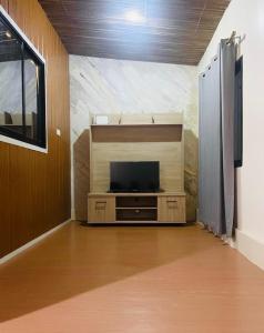 a room with a flat screen tv on a wall at GetAway Apartment in El Nido