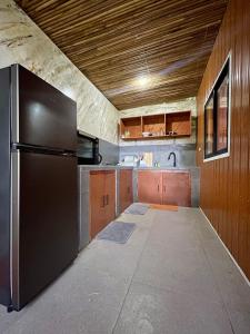 a kitchen with a stainless steel refrigerator and wooden cabinets at GetAway Apartment in El Nido
