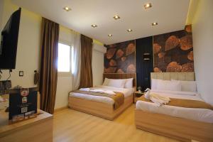 a hotel room with two beds and a flat screen tv at Palm Pyramids View INN in Cairo