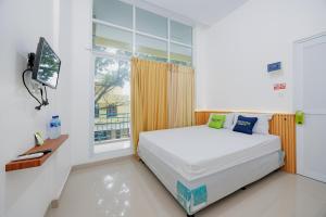 a bedroom with a bed and a window at Urbanview Hotel near Exit Tol BSD in Ciater-hilir