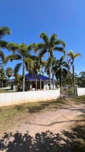 a house with palm trees in front of a fence at Liina House in Ko Yao Noi