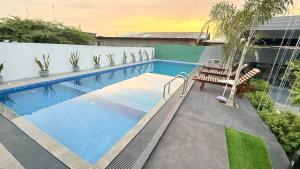 a large swimming pool with two chairs and a table at Sunset Villa in Hambantota