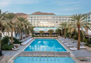 a hotel with a swimming pool and palm trees at Yam Suf by Isrotel Collection in Eilat