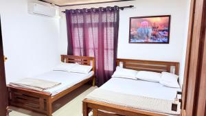 a room with two beds and a window at Sunset Villa in Hambantota