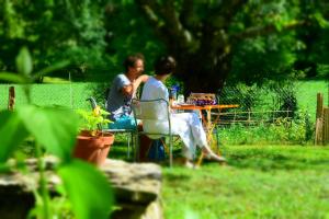 a man and a woman sitting at a table at Gîte La Source in Grusse