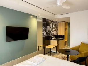 a hotel room with a bed and a tv on a wall at Kozi - Wilson Airport in Nairobi