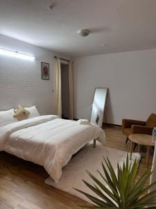 a bedroom with a large white bed and a table at Manang De cafe B and B in Kathmandu