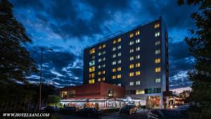 a building with cars parked in a parking lot at Hotel Sani in Asenovgrad