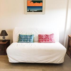 a white couch with pillows on it in a room at Lovely Central Apartment in Talamone