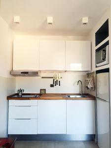 タラモーネにあるLovely Central Apartmentの白いキャビネットとシンク付きのキッチン