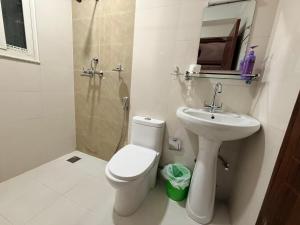 a white bathroom with a toilet and a sink at Sacred Trails Kathmandu Accommodation in Kathmandu +61 photos