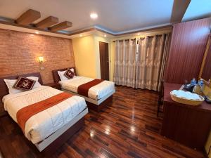a hotel room with two beds and a bathroom at Sacred Trails Kathmandu Accommodation in Kathmandu