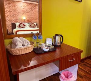 a bathroom with a table with towels and a mirror at Sacred Trails Kathmandu Accommodation in Kathmandu