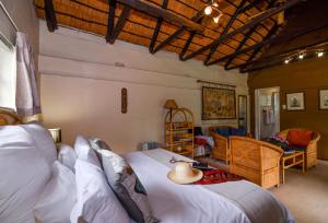 a bedroom with a bed with a hat on it at Random Harvest Country Cottages in Muldersdrift