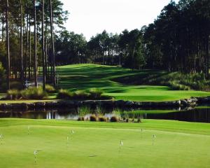 a golf course with a green and a pond at Golf & Beach Apartment in Charneca