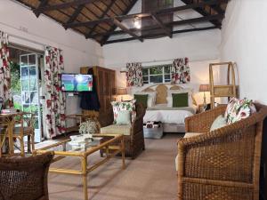 a living room with a bed and a table and chairs at Random Harvest Country Cottages in Muldersdrift