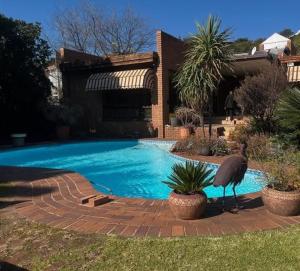 a large swimming pool in front of a house at Roxana Guestrooms in Johannesburg