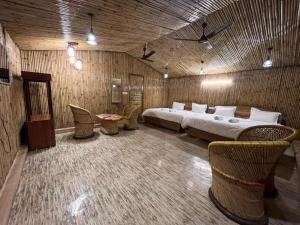 a bedroom with a bed and chairs in a room at Radhika resort in Vrindāvan