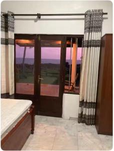a bedroom with a door with a view of a golf course at Dragon beach in Dondra West