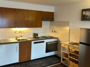 a kitchen with a sink and a stove at Apartment in Veysonnaz with pool in Veysonnaz