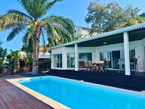 a house with a swimming pool in front of a house at Home Ocean 360 piscine chauffée et SPA in Saint-Leu