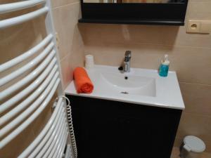 a bathroom sink with an orange towel on it at Penzion Pod Jáchymem in Dobrá Voda