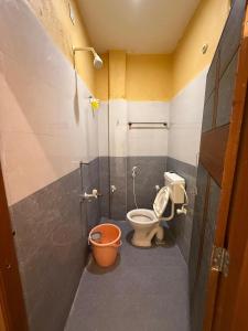 a bathroom with a toilet and a bucket at GYANi 1 in Tiruvannāmalai +28 photos