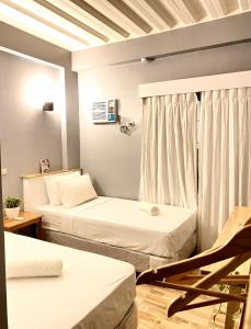 a room with two beds and a chair in it at Ahava Boutique Hotel in Pooc