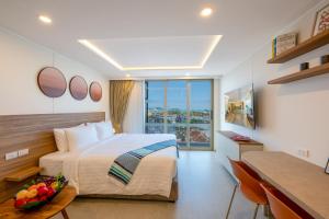 a bedroom with a bed and a table with a bowl of fruit at HOMA Chalong Bay in Ban Klang