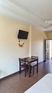 a room with a table and two chairs and a tv at ปราณบุรีน้อยรีสอร์ท in Ban Nong Sua