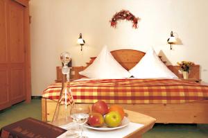 a bedroom with a bed with a plate of fruit on a table at Hotel zum Breitenberg in Bad Peterstal