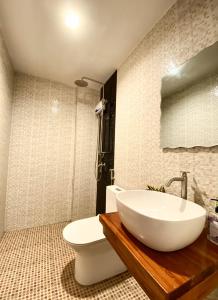 a bathroom with a white sink and a toilet at Ahava Boutique Hotel in Pooc