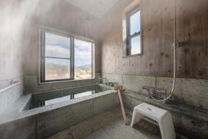 a bathroom with a bath tub and a toilet at 天然温泉-富士山パノラマビュー-プライベートデッキで非日常体験を-伊豆の温泉付き貸別荘-中伊豆noie in Izu +47 photos