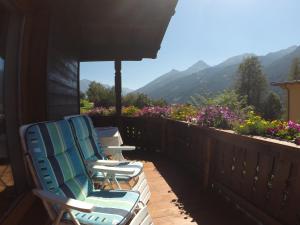 two chairs on a deck with mountains in the background at Privatzimmer Helene Mariacher in Virgen