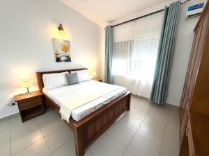 a bedroom with a large bed and a window at Nashu Three bedroom Townhouse in Dambani +55 photos