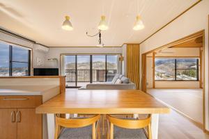 a kitchen and dining room with a table and a couch at 天然温泉-富士山パノラマビュー-プライベートデッキで非日常体験を-伊豆の温泉付き貸別荘-中伊豆noie in Izu