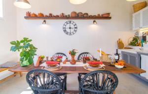 a dining room table with chairs and a clock on the wall at Casa Gema in El Port de la Selva