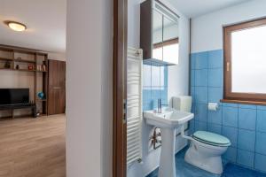 a bathroom with a toilet and a sink at Grandma’s Cottage in Săcele +28 photos