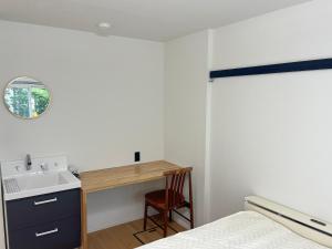 a bedroom with a sink and a desk with a bed at フレグランスショーワ in Matsue +4 photos