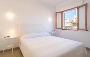 a white bedroom with a bed and a window at Convent in Alcudia +34 photos