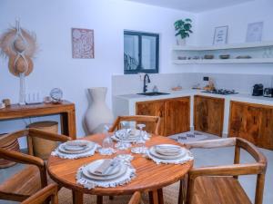 a kitchen with a wooden table and four chairs at Villa Moja in Nungwi