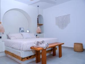 a white bedroom with a bed and a wooden table at Villa Moja in Nungwi