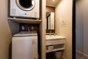 une petite salle de bains avec lave-linge et lavabo dans l'établissement PORTO7-5, à Chatan 135 autres photos