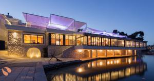 a large house with a river in front of it at Ribarska Koliba Resort in Pula