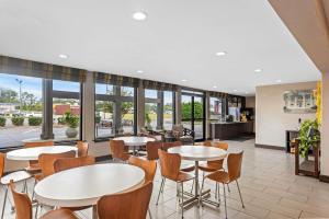 a restaurant with tables and chairs and windows at Super 8 by Wyndham Valdosta GA I-75 in Valdosta