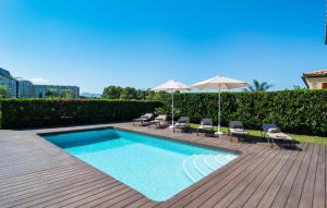 a swimming pool with chairs and umbrellas on a deck at Montelago in Alcudia