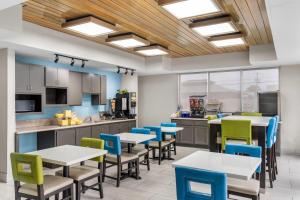 a cafeteria with tables and chairs and a kitchen at Days Inn & Suites by Wyndham Ridgeland in Ridgeland
