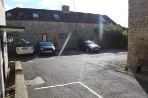 two cars parked in a parking lot with a water hose at Brewery Farm House Bed & Breakfast in Swindon